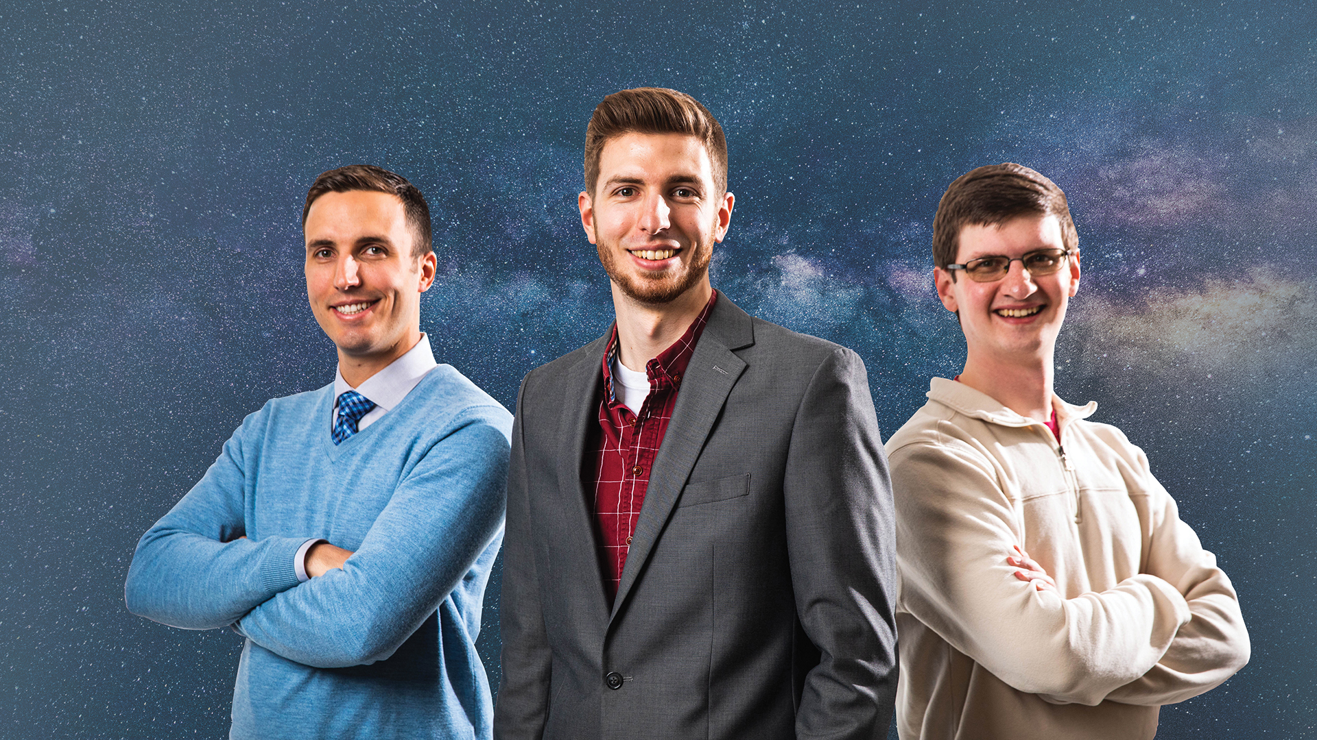 3 K M I employees posed with the one in center's hands in his pockets and the two next to him have their arms crossed.