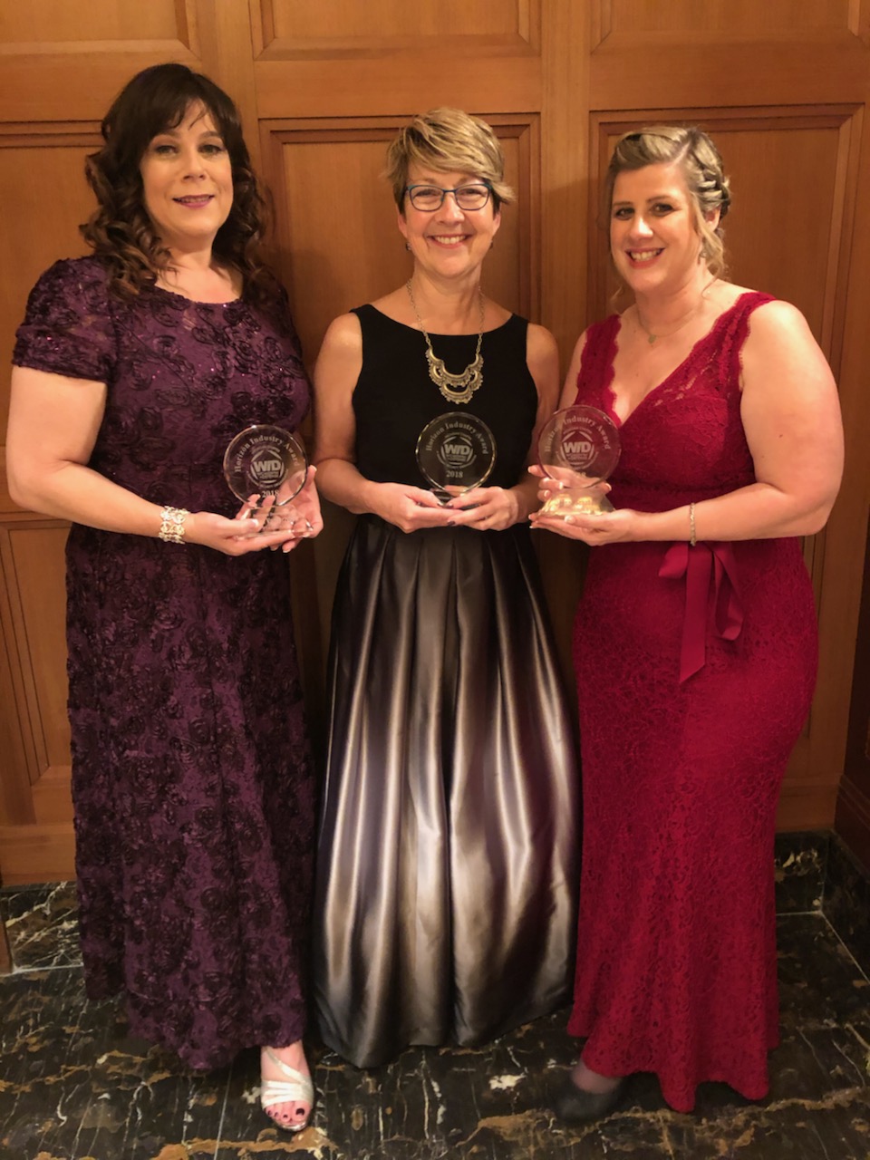 Cathy Fairbanks posed in center with Defense Industry Award with two other women on each side